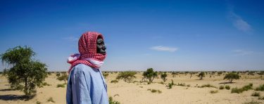 Man looking across a desert landscape