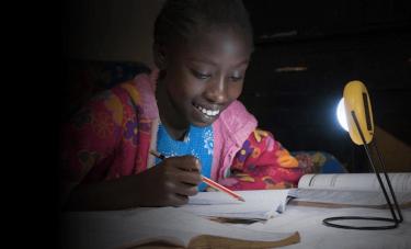 A girl studying with a solar lamp in Nigeria