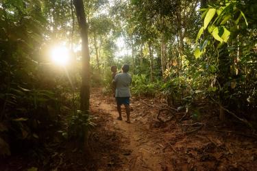 Persona con niño en brazos caminando en el bosque en Bolivia