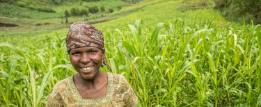 Une femme souriant dans un champ en République Démocratique du Congo