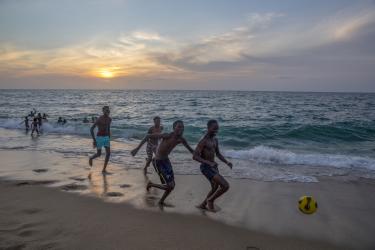 Jóvenes jugando al fútbol en una playa de Angola