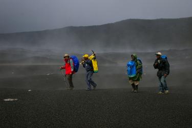 Men walking in a volcanic area in Comoros