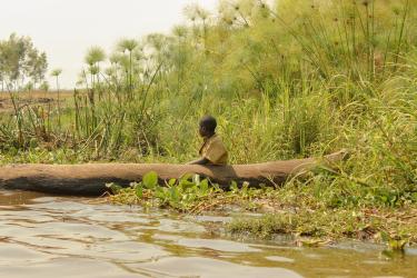 A child in a small boat by the river in Rwanda