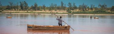 Un homme sur une barque récoltant du sel au Lac rose au Sénégal.