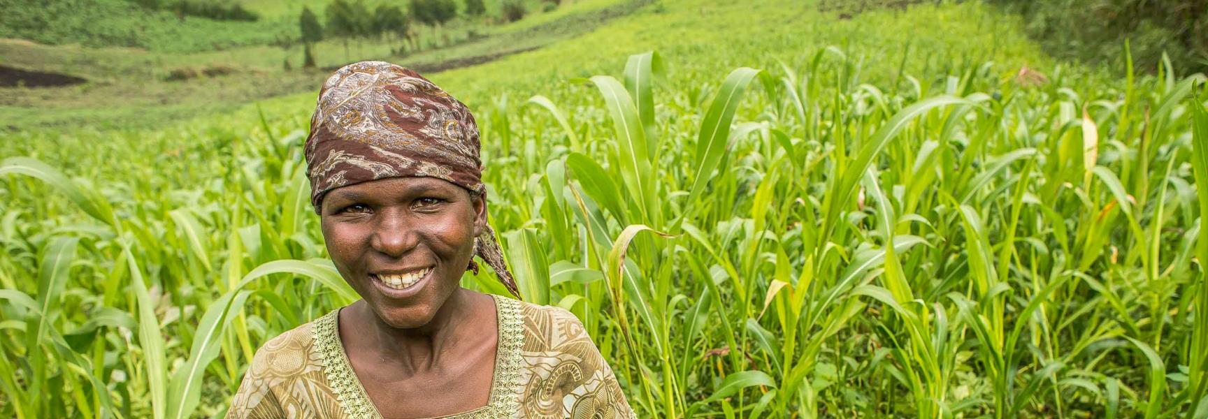 Une femme souriant dans un champ en République Démocratique du Congo