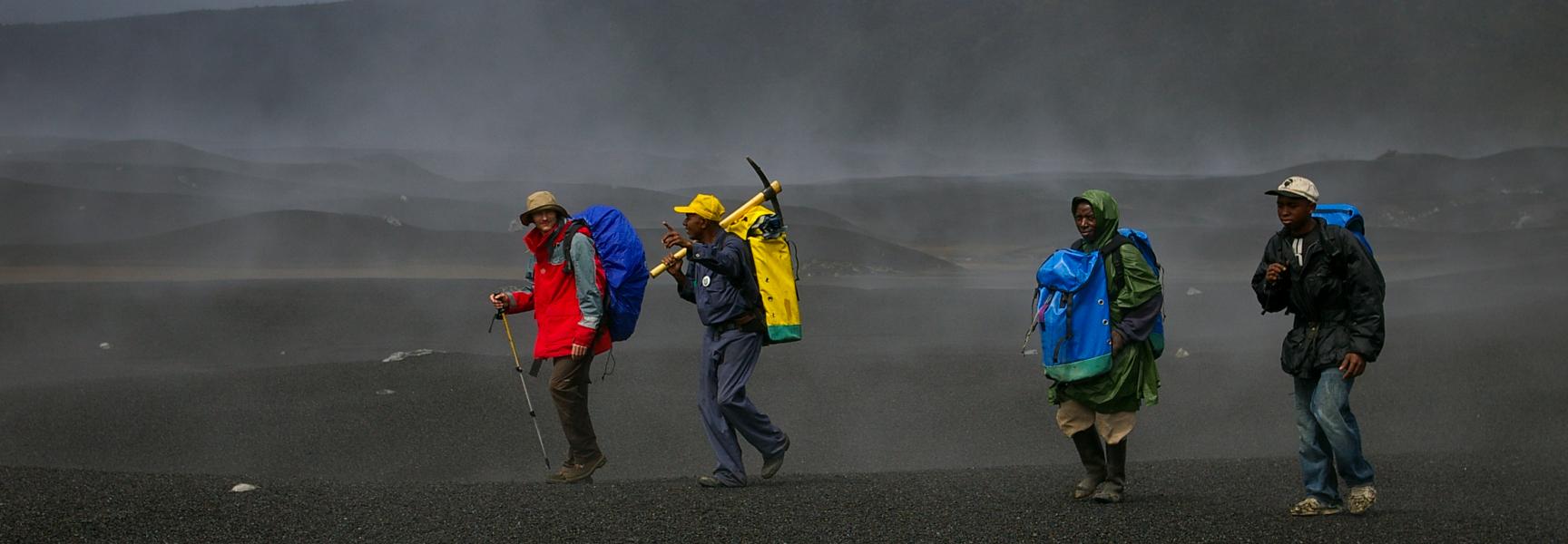 Men walking in a volcanic area in Comoros